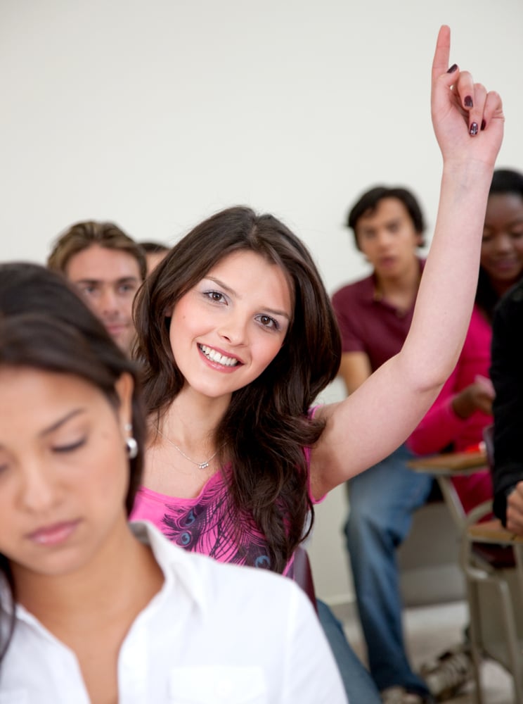 Female student in a classroom - participating and smiling Female student in a classroom - participating and smiling